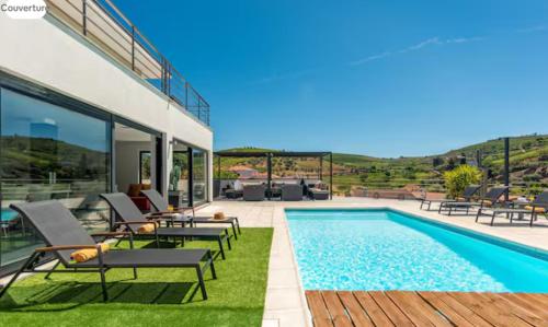 a villa with a swimming pool and a patio at Valadouro Amazing Villa in Douro Valley - Pool in Espinhosa