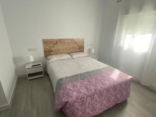 a bedroom with a large bed and a window at Apartamento tranquilo y luminoso in Arcos de la Frontera