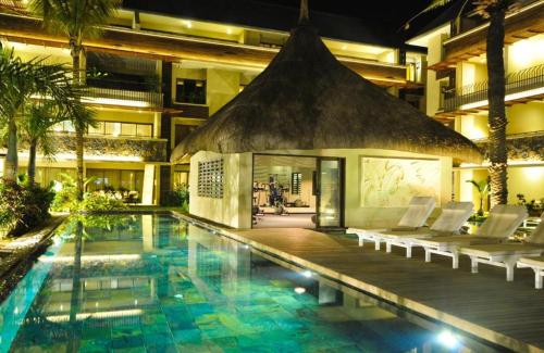 a swimming pool with chairs and a building at Grand Baie Domaine des Alizées Club & Spa in Grand Baie