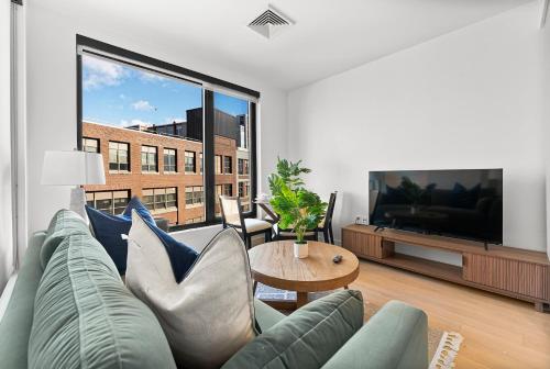 a living room with a couch and a flat screen tv at Furnished Apartment in South Boston in Boston