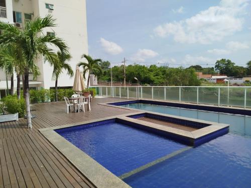 a swimming pool with a table and a umbrella on a building at Apartamento na João XXIII in Teresina