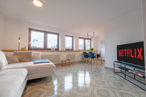 a living room with a couch and a tv at SCHLOSSBERG RESIDENCES - Design-Apartments im Herzen der Pfalz in Sankt Martin