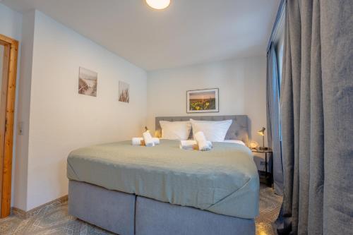 a bedroom with a bed with two pillows at SCHLOSSBERG RESIDENCES - Design-Apartments im Herzen der Pfalz in Sankt Martin