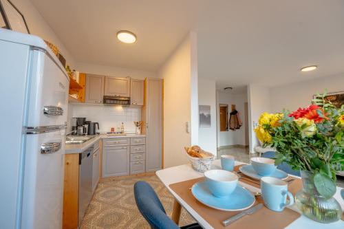 a kitchen with a table with a vase of flowers on it at SCHLOSSBERG RESIDENCES - Design-Apartments im Herzen der Pfalz in Sankt Martin