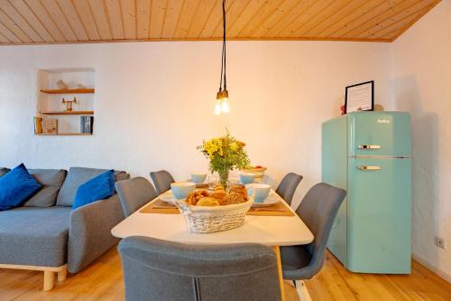 a living room with a table and a blue refrigerator at SCHLOSSBERG RESIDENCES - Design-Apartments im Herzen der Pfalz in Sankt Martin