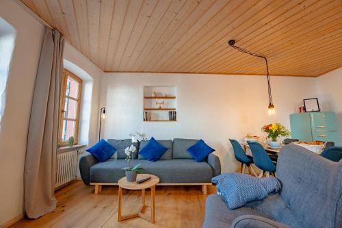 a living room with a blue couch and a table at SCHLOSSBERG RESIDENCES - Design-Apartments im Herzen der Pfalz in Sankt Martin