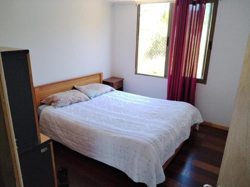 a bedroom with a bed and a window at Cabaña familiar y piscina valentina in Laguna Verde