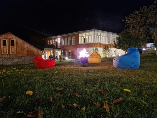 a group of tents in the grass in front of a building at Brick House in Lahıc