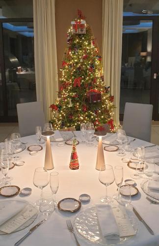 a table with wine glasses and a christmas tree at Il Castagneto Hotel in Melfi