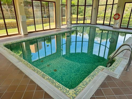 an indoor swimming pool with a chair and a table at Piso de lujo Golf y Playa in Estepona