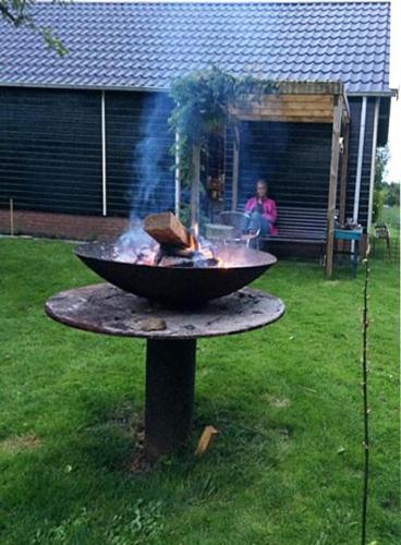 a bbq grill on a table in a yard at Vakantiehuisje De Waddenuil in Usquert