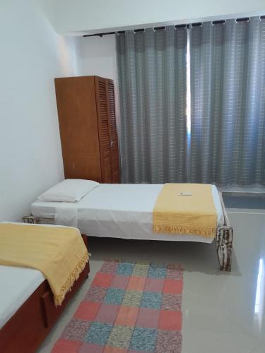 una camera da letto con due letti e un tappeto di Casa Marisol Maresias a São Sebastião