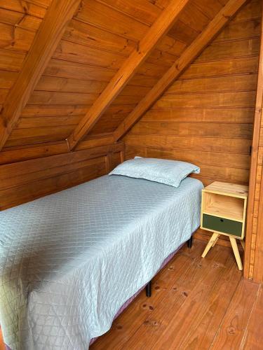 a bed in a room with a wooden ceiling at Pousada Chalé Flor de Hibisco 3 in Penha