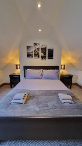 a bedroom with a large bed with two towels on it at 3 Treig Road in Fort William
