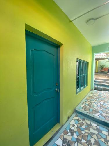 a blue door in the corner of a yellow wall at Casa Azul - Apartment in San Felipe de Puerto Plata