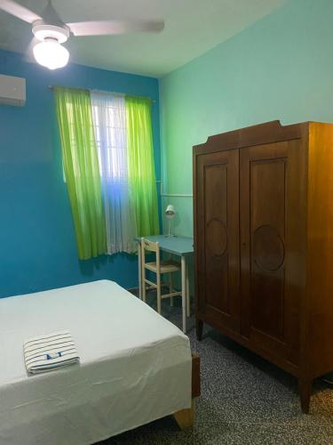 a bedroom with a bed and a dresser and a table at Casa Azul - Apartment in San Felipe de Puerto Plata