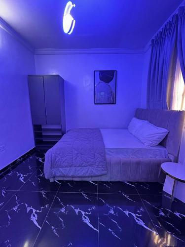 a bedroom with a bed and a table in a purple room at The Apartment at Akoka Yaba, Lagos - House 16 Shobande Street in Yaba