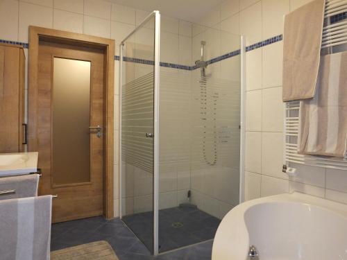 a bathroom with a tub and a glass shower at Ferienwohnung ganz nah in Piding