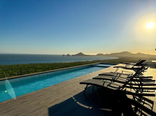 eine Gruppe von Stühlen neben einem Swimmingpool in der Unterkunft Departamento de lujo in Cabo San Lucas