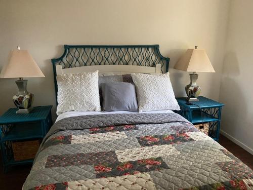 a bedroom with a bed with two blue tables at Charming 2-Bedroom Condo in Enchanting Palm Spring in Palm Springs