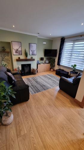 a living room with two couches and a television at 3 Treig Road in Fort William