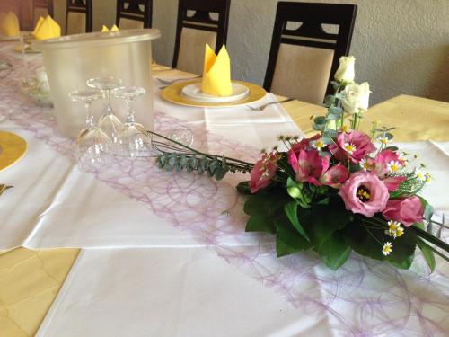a table with a bouquet of pink flowers on it at Hotel & Restaurant Park Cafe ISA in Erfurt