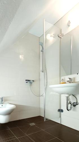 a white bathroom with a sink and a shower at Ferienwohnung Michelle mit Balkon für 1 - 6 Personen in Warmensteinach