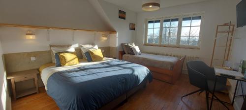 a bedroom with a bed and a desk and a chair at Villa Maëlla- Gîtes en Normandie, tout confort, SPA et Piscine in Saint-Michel-la-Forêt