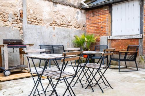 - un ensemble de tables et de chaises assises sur une terrasse dans l'établissement Studio cosy RDC, calme avec cour extérieure, à Saran