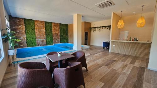 a swimming pool in a room with a table and chairs at Mensú Grand Hotel in Puerto Iguazú