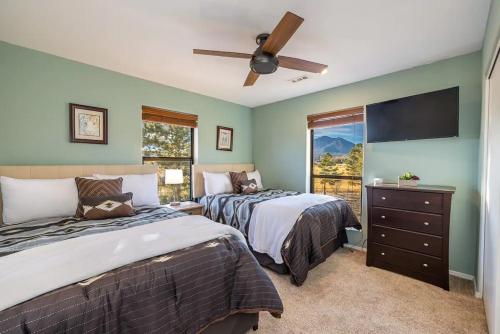 a bedroom with two beds and a flat screen tv at Flagstaff Family Retreat in Flagstaff