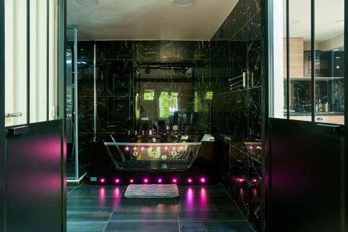 a bathroom with a tub with purple lights at Versailles One Sauna & Jacuzzi in Versailles
