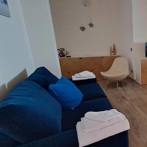 a living room with a blue couch and a chair at Dream Apartments Moena in Moena