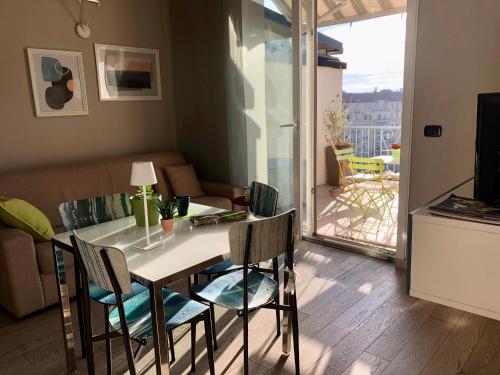 a dining room with a table and chairs and a balcony at Attico Ellen terrazza con vista in Turin