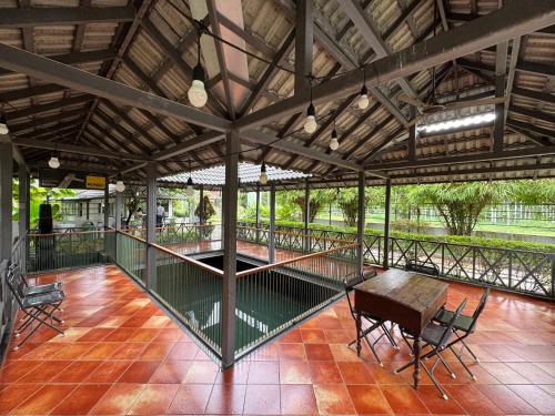 a pavilion with a table and chairs on a patio at Royad Calicut Farm House - Premium Villa with Pool Inside a Farm in Kozhikode
