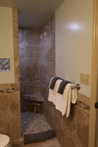 a bathroom with a shower with a toilet and towels at Harvest House Bed and Breakfast in Springdale