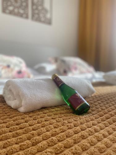 a bottle of alcohol sitting on top of a bed at Labela Luhačovice Apartment in Luhačovice