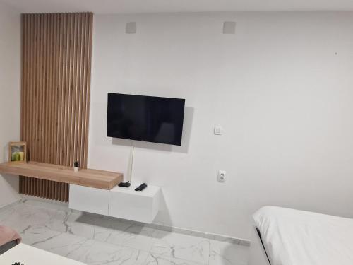 a living room with a tv on a white wall at Apartmani MODUS - SELF-CHECK-IN in Virovitica
