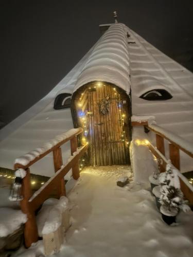 a snow covered igloo with a gate and lights at Mała Bawaria in Zakopane