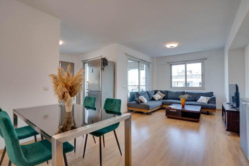 a living room with a table and green chairs at Spacious Modern 3bd Apt In Prestigious Engomi in Ayios Dhometios