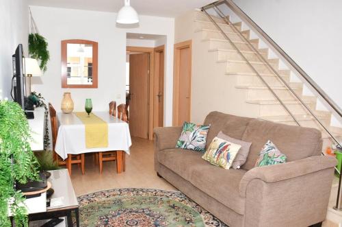 a living room with a couch and a staircase at Casa Caleta, Beautiful 3-Bed Home, large patio & communal pool in Fuerteventura