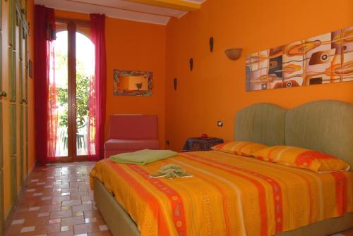 a bedroom with a bed with an orange wall at La Dimora le Fumarole Rooms in Ercolano