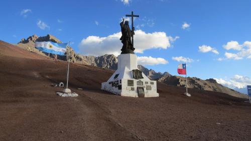a statue of a man with a cross on a mountain at Portezuelo del Viento - Hostel de Montaña in Las Cuevas