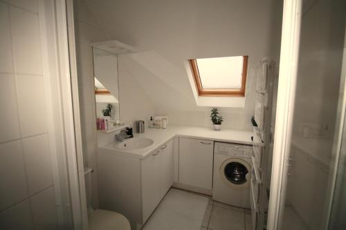 une petite salle de bains blanche avec lavabo et lave-linge. dans l'établissement appartement vue mer, à Wimereux