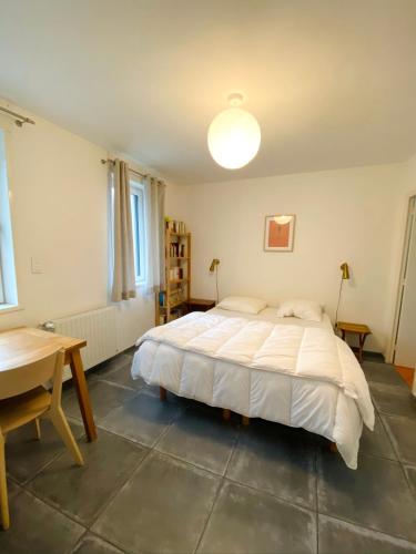une chambre avec un lit, une table et un bureau dans l'établissement Les Bulots - Charmante villa wissantaise, à Wissant