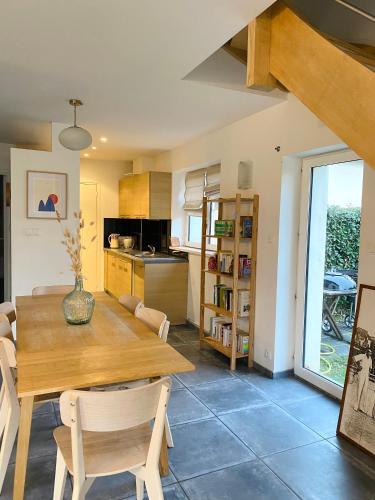 une cuisine et une salle à manger avec une table et des chaises en bois dans l'établissement Les Bulots - Charmante villa wissantaise, à Wissant