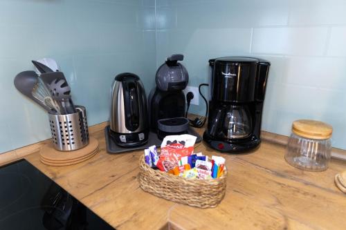 - un comptoir avec un panier de bonbons et une cafetière dans l'établissement L'Orée des Thermes, à Niederbronn-les-Bains