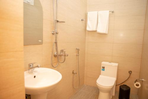 a bathroom with a shower and a toilet and a sink at Nomad Inn Nizwa in Nizwa