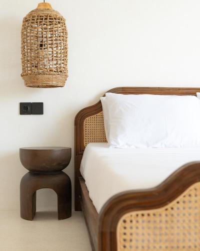 a bedroom with a bed with a chair and a basket at Tyde Bali Boutique Hotel in Uluwatu