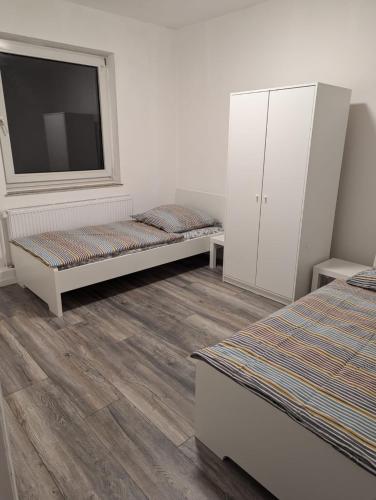 a room with two beds and a window and a tv at La vins Apartments in Bremen
